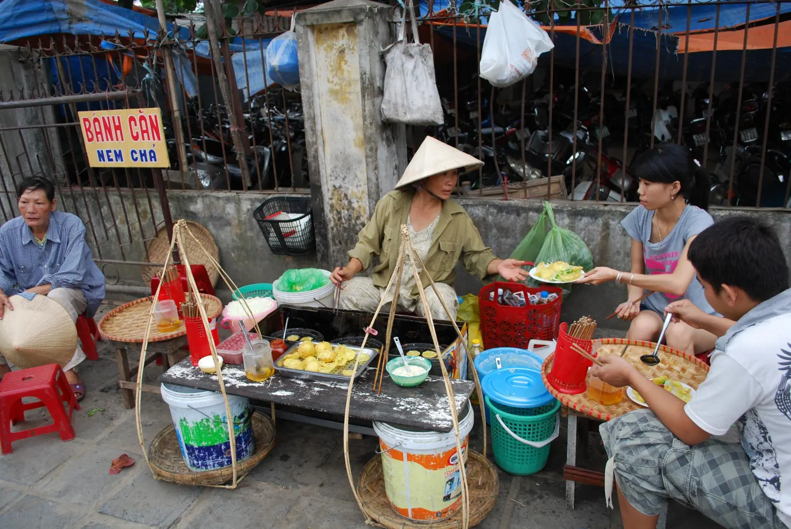 A hawker cooking banh can and nem cha.
